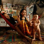 Chan Sreynoch, 23, with her husband Touh Sopheak, 24, and son, Khon Bopha, 7 months, in their home- an abandoned wooden train carriage. -- CAROLINE CHIA/THE STRAITS TIMES 